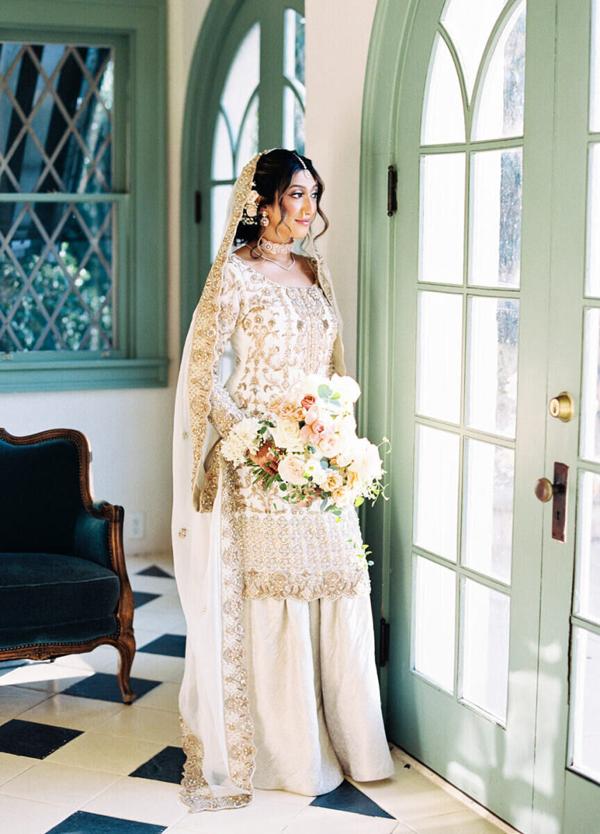 Wedding Dress Shopping: A bride looking out a window while holding her bouquet on her wedding day.