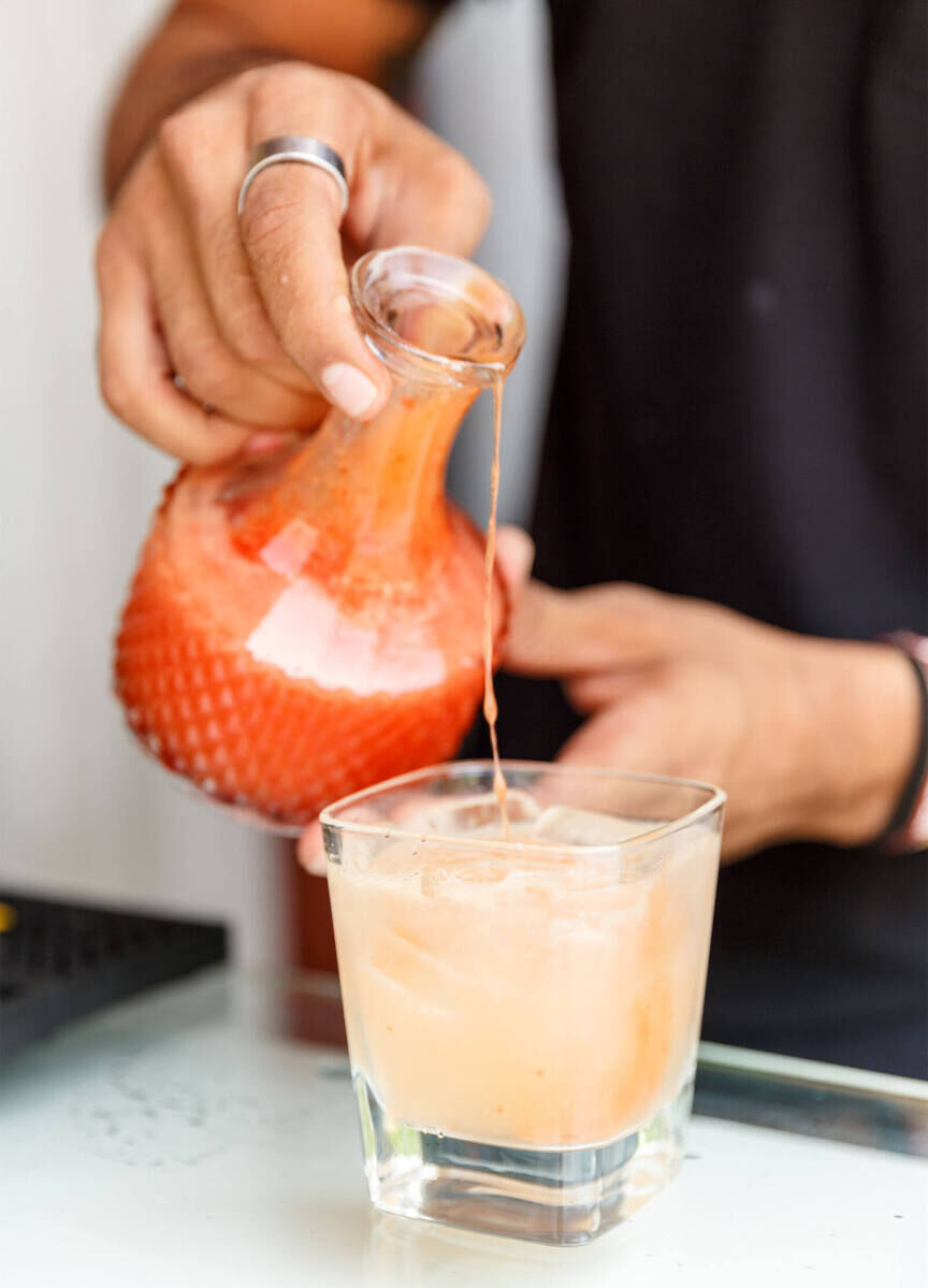 Wedding Drinks: A server pouring a tequila drink into a glass.