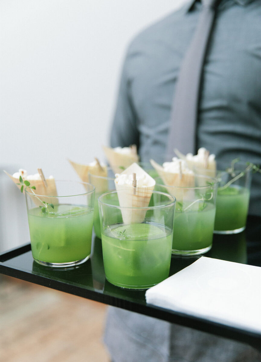 Wedding Drinks: Six bright green cocktails on a serving tray held by a server in a gray shirt and tie.