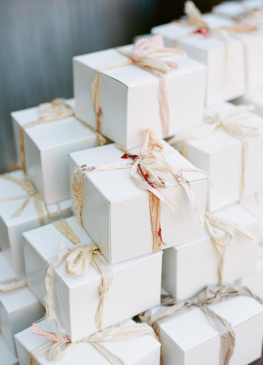 Wedding Etiquette: A pile of white gift boxes wrapped with a soft pink printed ribbon.