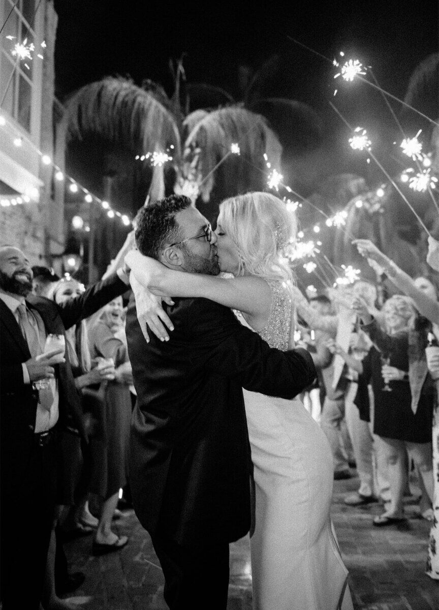 Wedding Fireworks Wedding Sparklers: A bride and groom kissing with guests holding sparklers in the background.