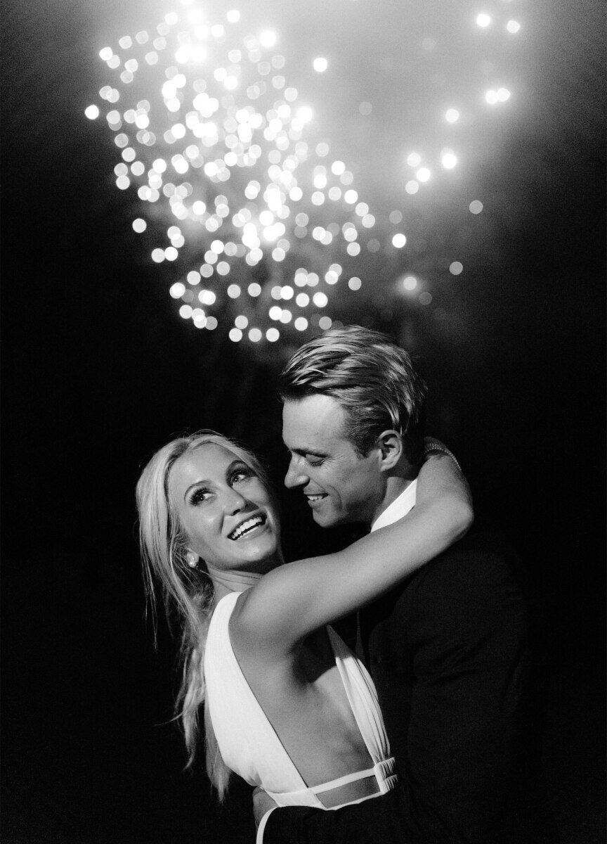 Wedding Fireworks Wedding Sparklers: A wedding couple smiling with a big firework above them.