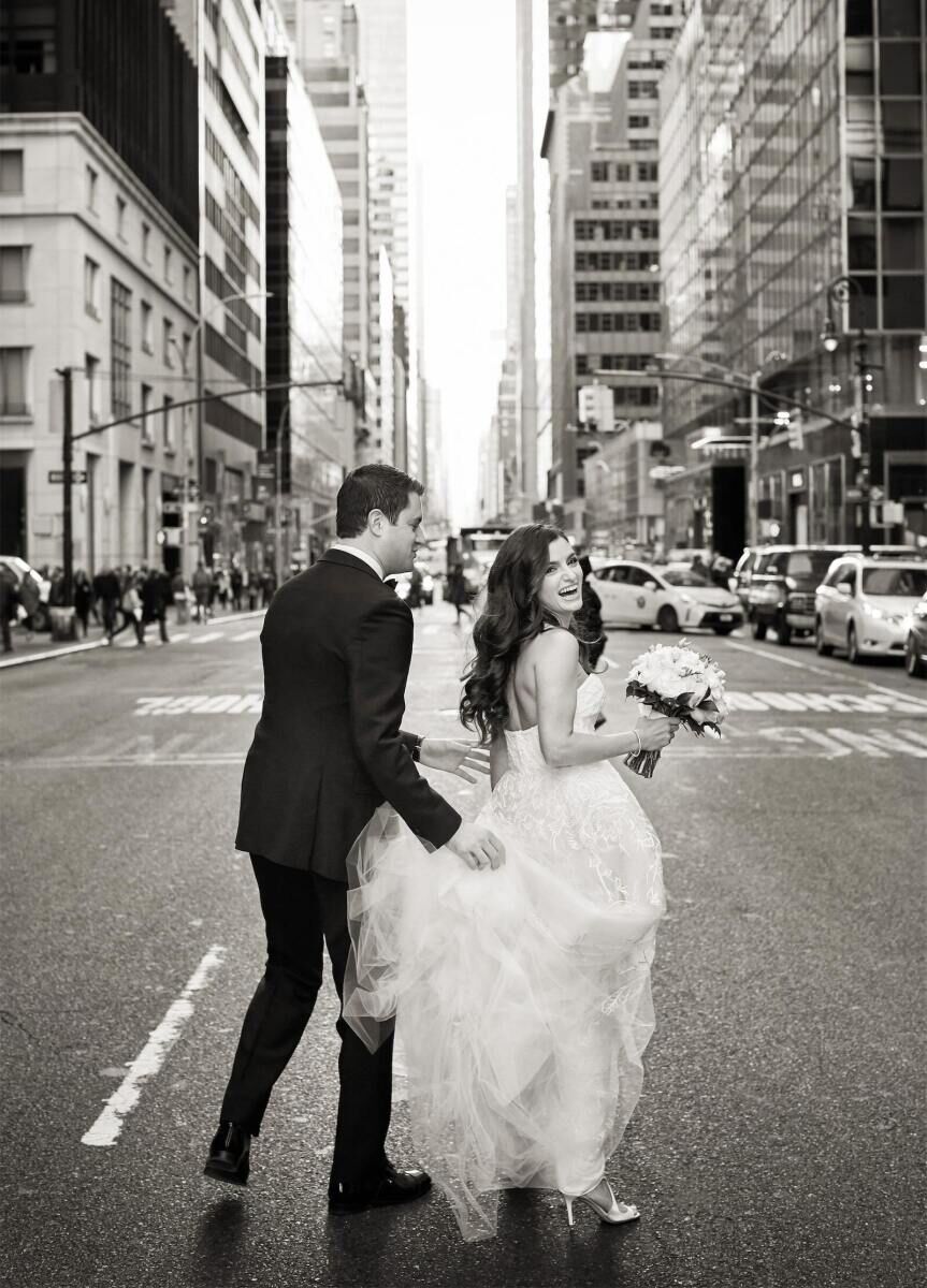 Wedding Photography Ideas: A bride looking back at the camera as she and the groom cross a New York City street.