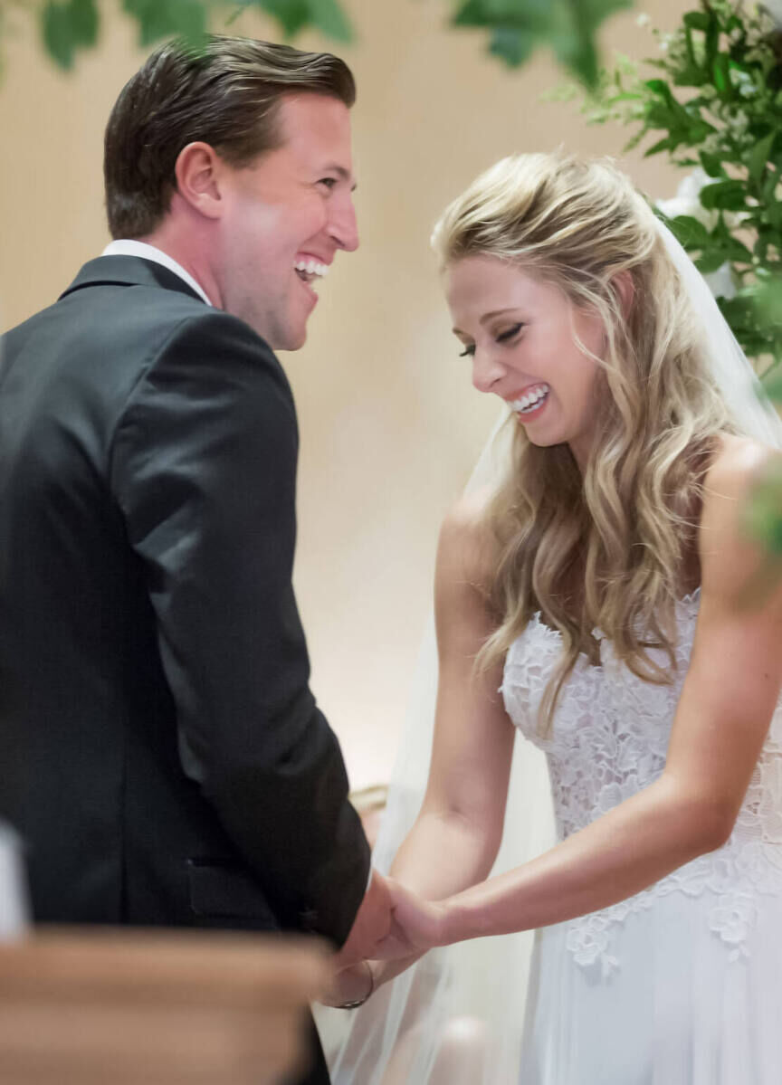 Wedding Photography Ideas: A candid moment showing a wedding couple laughing while holding hands.