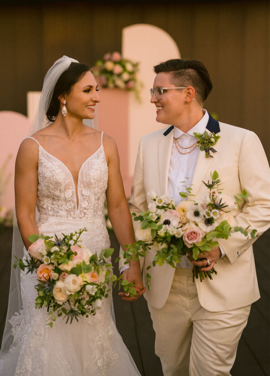 Wedding Photography Ideas: A wedding couple smiling at each other while holding their own bouquets.