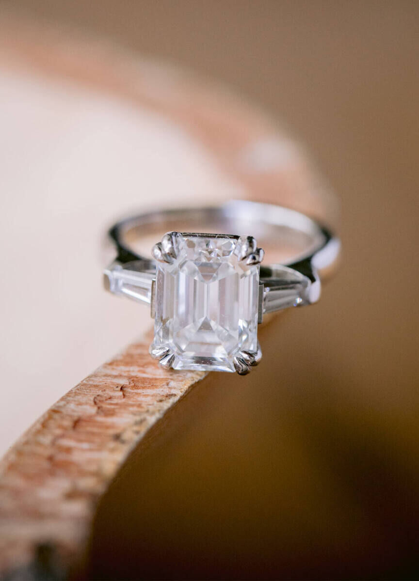 Wedding Ring Design: An emerald cut engagement ring sitting on a table.