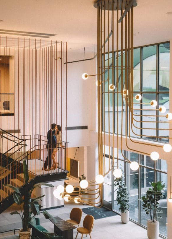 Wedding Venues in California: A couple embracing on the staircase in the lobby of a modern hotel in San Francisco.