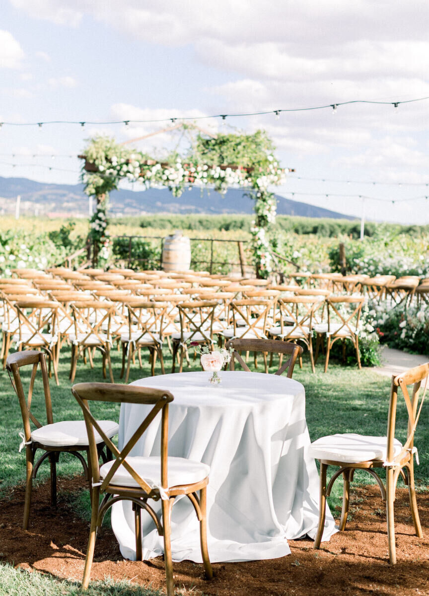 Wedding Venues in California: An outdoor ceremony with white-cushioned wooden chairs in a vineyard in Temecula, California.