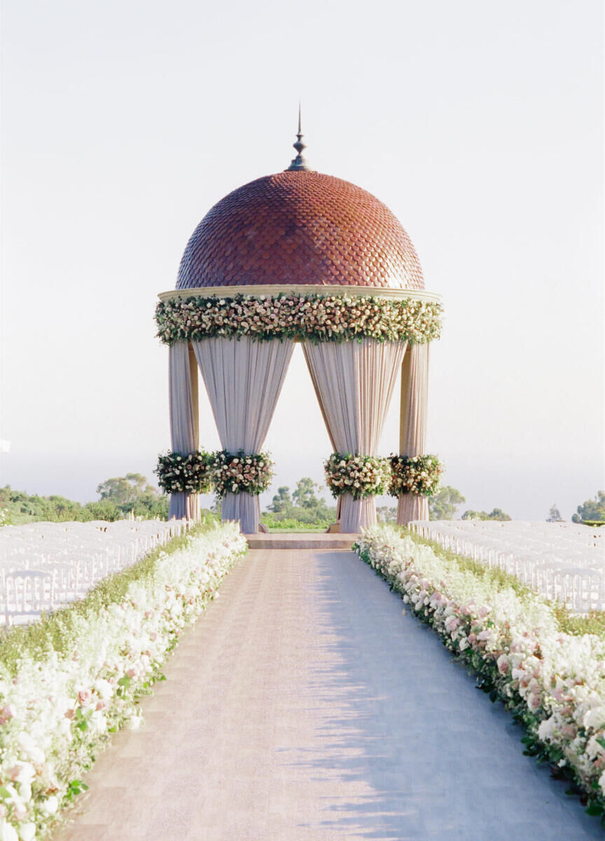 Wedding Venues in California: A floral-lined aisle leading up to a tiled gazebo covered in greenery and flowers.