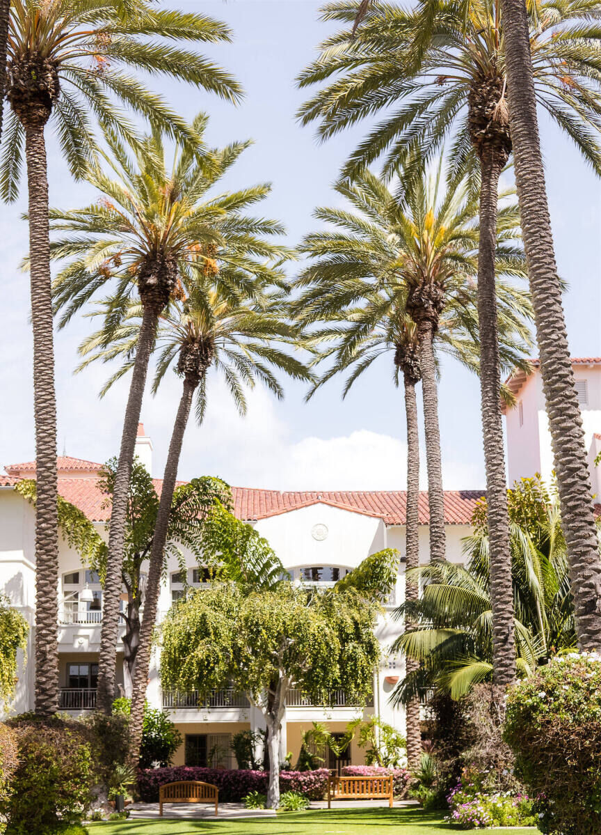 Wedding Venues in California: A Carlsbad, California hotel will Spanish architecture and palm trees in the foreground.