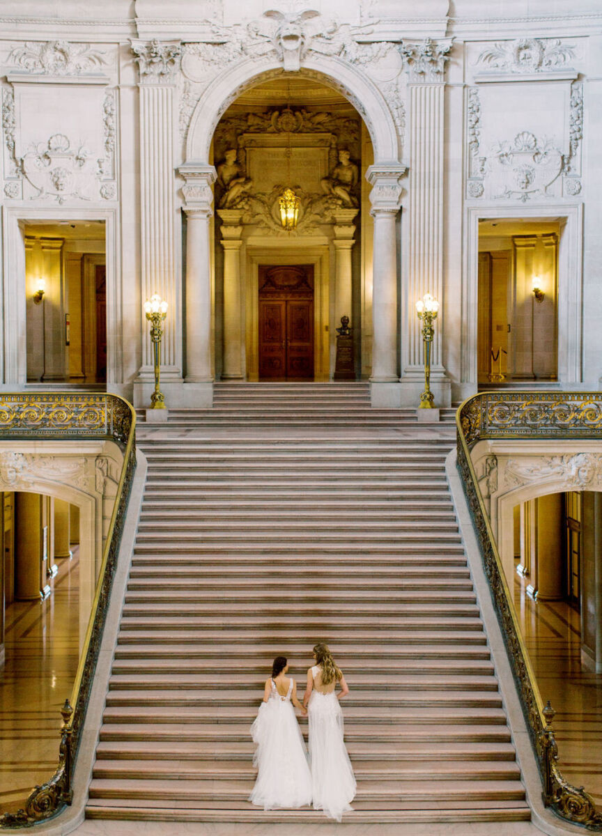 Wedding Venues in California: Two brides walking up a long staircase at San Francisco City Hall.