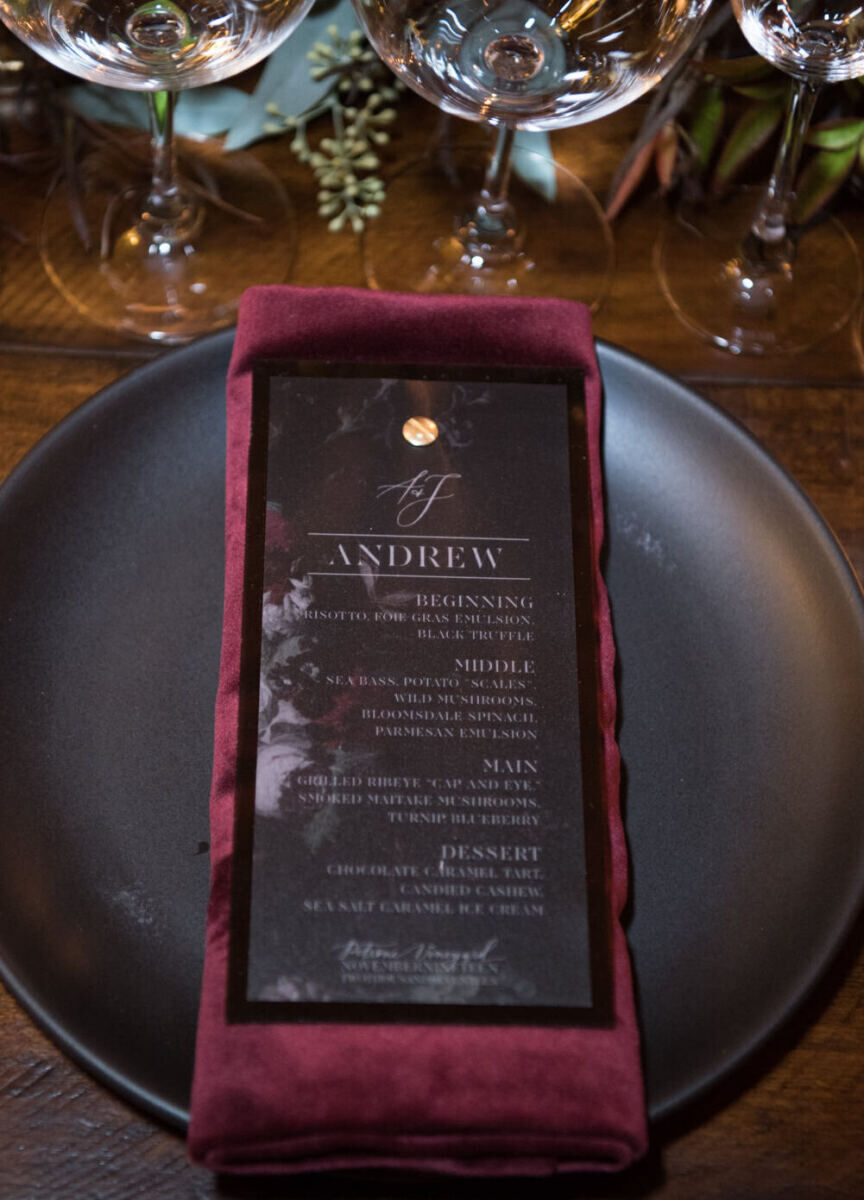 Wedding Website Examples: A wedding place setting with a dark red napkin and coordinating menu.