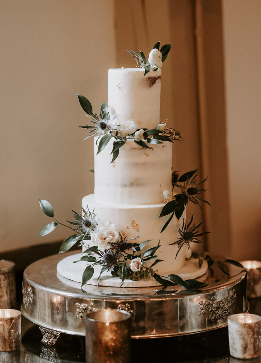 Wedding Website Examples: A three-tiered wedding cake with leaf and floral accents.