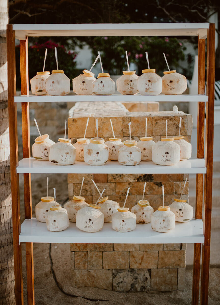 Coconuts were customized with the couple's monogram and palm tree logo at the welcome party the night before their Cabo wedding.