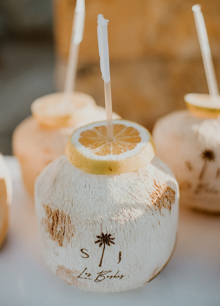 Initials and a palm tree appeared on coconuts served during a Cabo wedding weekend.