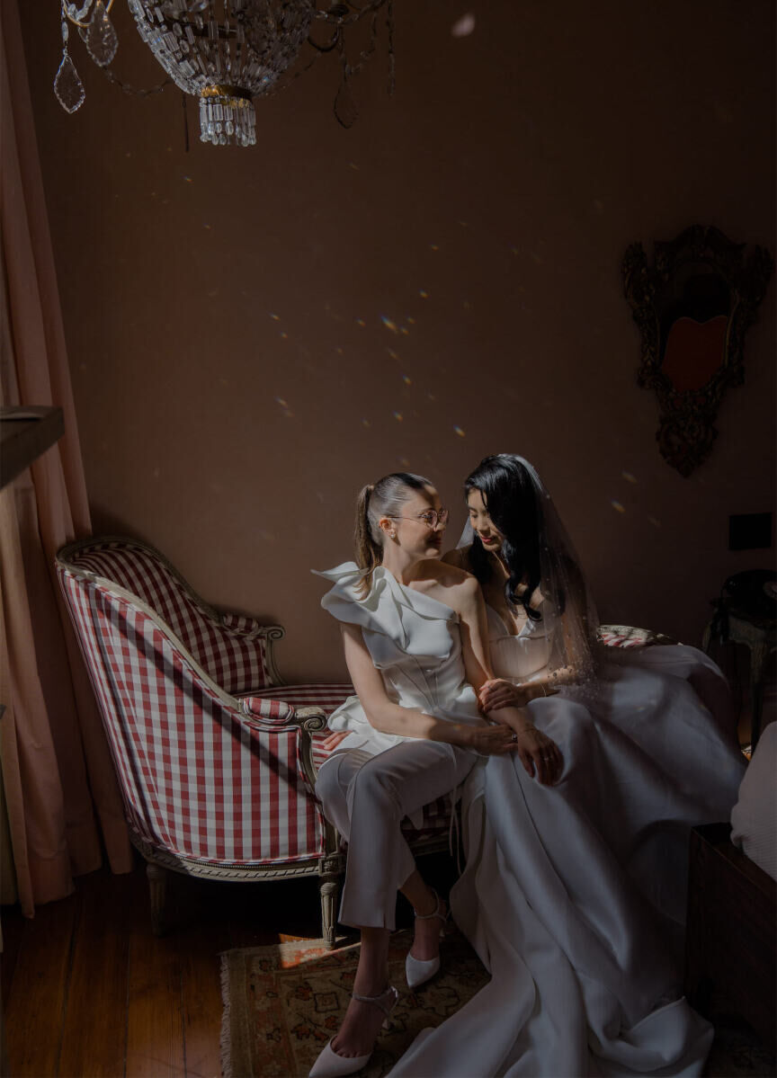 A quiet moment between two brides, post-ceremony at their whimsical wedding.