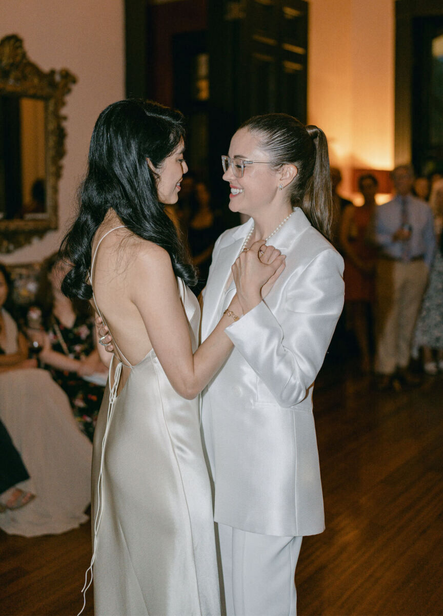 Newlywed brides share their first dance during their whimsical wedding reception.