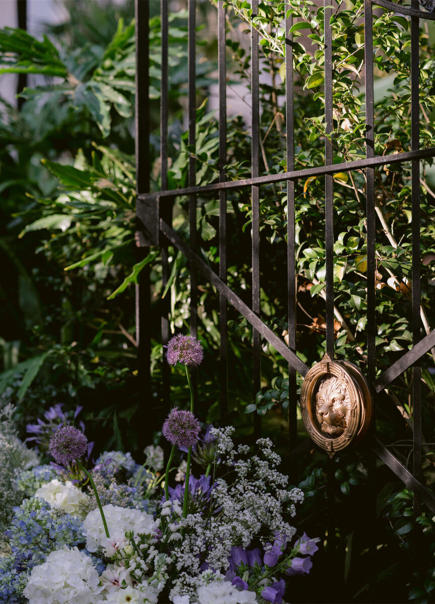 In typical New Orleans fashion, iron work was part of the setting for a whimsical wedding reception, as were fresh flowers in colors like cornflower blue and soft purple.