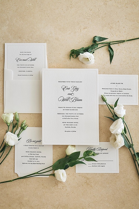 Wedding invitation suite with letterpress wedding invitation, envelopes, RSVP and save the date cards, styled with white flowers on stone surface