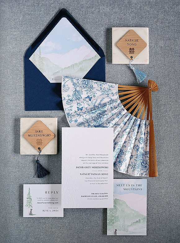 Invitation suite wedding invitation flat lay with navy envelope, watercolor liner, letterpress cards, tassels and double happiness symbol on gray fabric