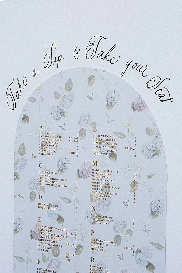 Wedding seating chart acrylic seating chart sign with gold calligraphy, floral and butterfly illustrations on a clean white background