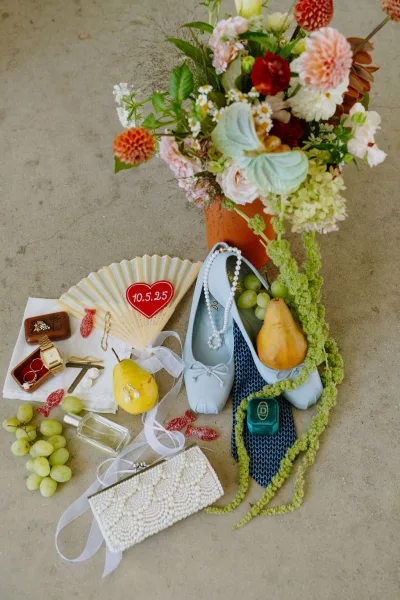 Wedding details flat lay with a bridal accessories flat lay highlighting pearl jewelry arranged neatly on a concrete floor