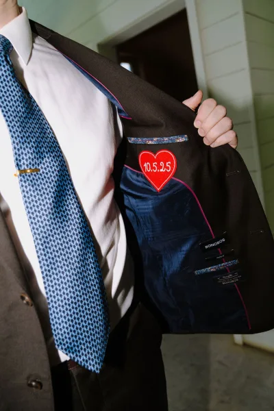 Custom suit lining highlighted as a groom suit detail, featuring an embroidered heart patch hidden inside the jacket for a sentimental touch.