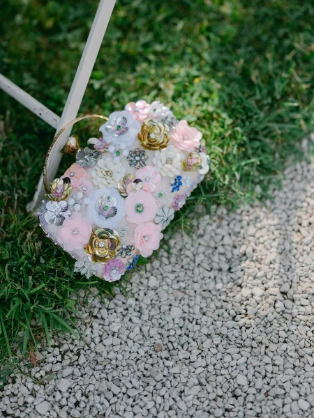 Bridal clutch, a floral bridal purse with a sleek ring handle, covered in dimensional blossoms for an elegant statement at the wedding