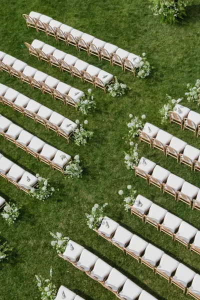 Ceremony seating along the garden lawn showcases elegant ceremony aisle design with wood chairs and a clean, natural flow.