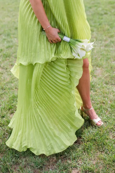Lime green bridesmaid dress, a pleated bridesmaid dress style, paired with a white calla lily bouquet.