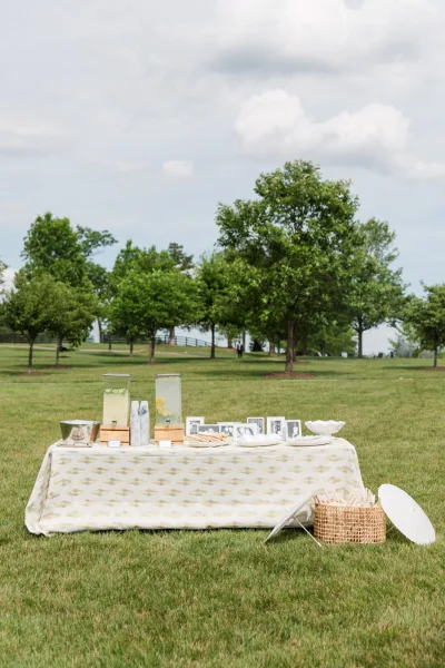 Wedding refreshment station and lemonade drink station featuring a basket of paper parasols for guests.