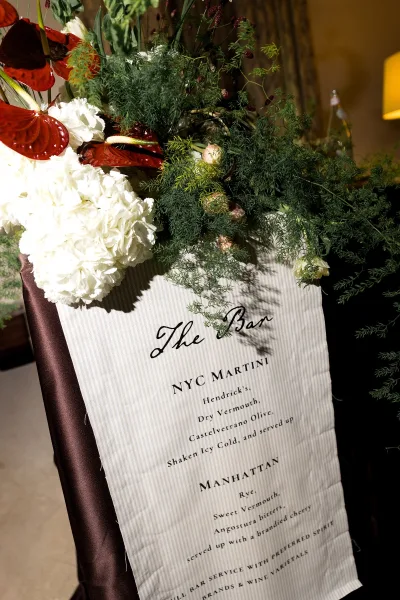 Wedding bar sign and cocktail menu sign styled with white hydrangea accents for a refined reception display.