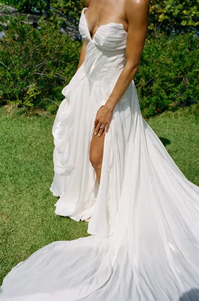 Wedding dress close-up of a strapless wedding dress with a sweetheart neckline, set against garden greenery.