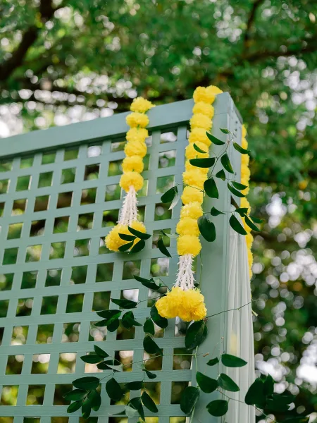 Ceremony backdrop styled as elegant outdoor ceremony decor, featuring cascading floral garlands that frame a clean, minimal focal point.