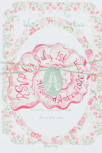Wedding invitation suite featuring floral wedding invitations with scalloped edges and romantic script, arranged as a coordinated set.