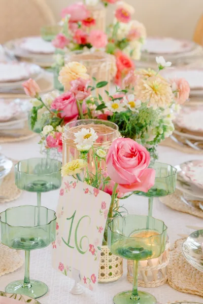 Reception tablescape for spring wedding table decor, featuring green coupe glasses and a soft pastel palette.