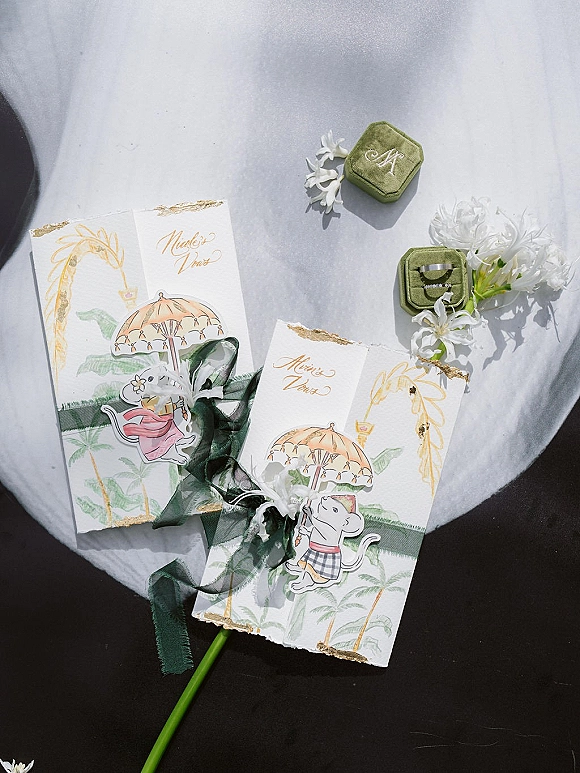 Invitation suite wedding invitation set with deckle edge paper, gold foil edging, watercolor illustration, rings, and white flowers on fabric backdrop