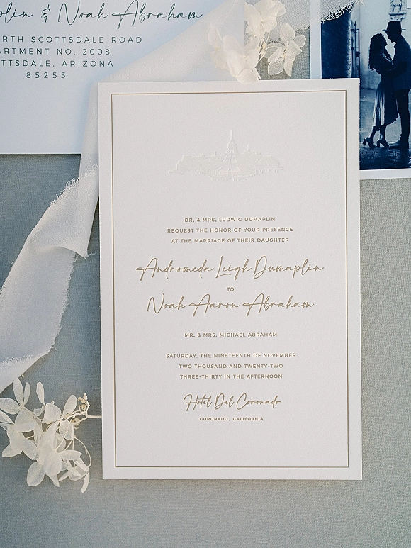 Wedding invitation suite with letterpress wedding invitations, deckled edge cards and silk ribbon, arranged on a gray fabric backdrop