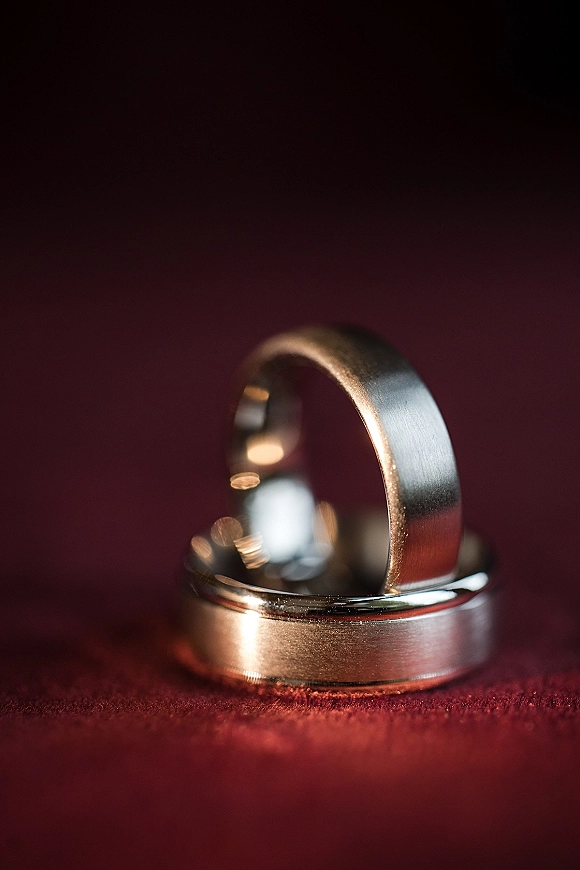 Wedding rings stacked as a wedding band set of metal bands on a red fabric surface, shown in close-up detail
