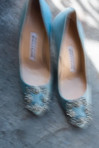 Bridal shoes in blue satin pumps with a rhinestone buckle and pointed toe, shown in a flat lay on light fabric with soft shadows