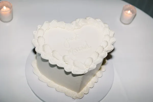 Wedding cake, heart-shaped wedding cake with smooth buttercream and 'Just Married' piped lettering, a minimalist, classic design.