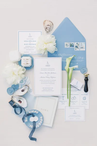 Wedding invitation suite styled as nautical wedding invitations, a flat lay on linen fabric with oyster shells enhancing the coastal theme.