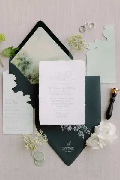 Wedding invitation suite with a handmade paper invitation, styled with wax seals on linen fabric for a refined, elegant presentation.
