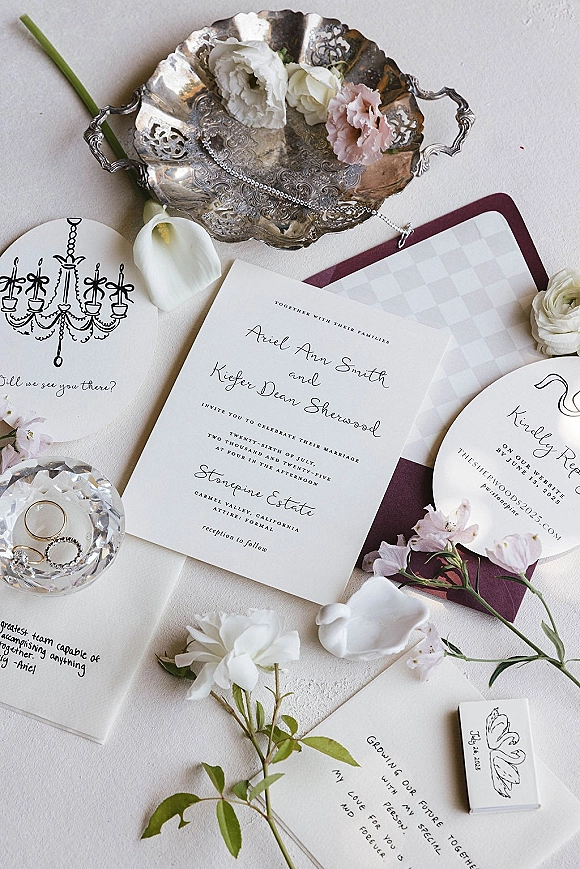 Invitation suite wedding invitation flat lay with RSVP and details cards, rings in a crystal dish, florals and wax seal on linen fabric surface