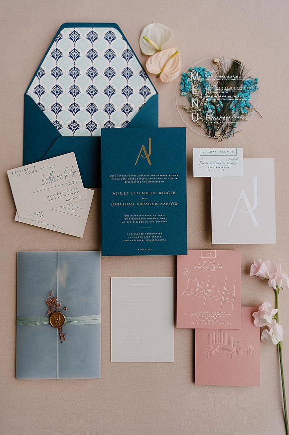 Invitation suite wedding invitation flat lay with monogram, wax seal, ribbon wrap, RSVP and details cards on a neutral fabric backdrop