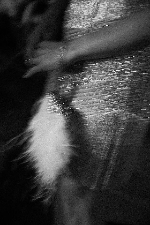 Wedding dress detail with beaded wedding dress sequins shimmering on sheer fabric against a dark background for a dramatic close-up