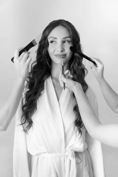 Bride getting ready during bridal makeup application as a lip brush defines her lips, a composed moment highlighting delicate detail.