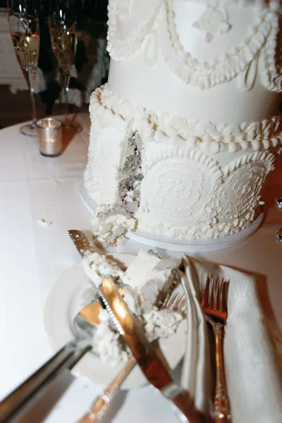 Wedding cake, a white wedding cake ready for cutting with a cake slice on a plate beside it, set for a classic celebration.