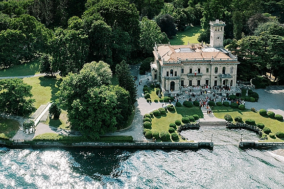 Wedding venue with estate wedding venue grounds, showing gazebo and outdoor ceremony chairs on a terrace by a lakefront mansion lawn