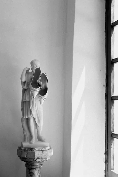 Bridal shoes, elegant slingback bridal heels displayed on a marble statue, highlighting fine art styling and sculptural detail.